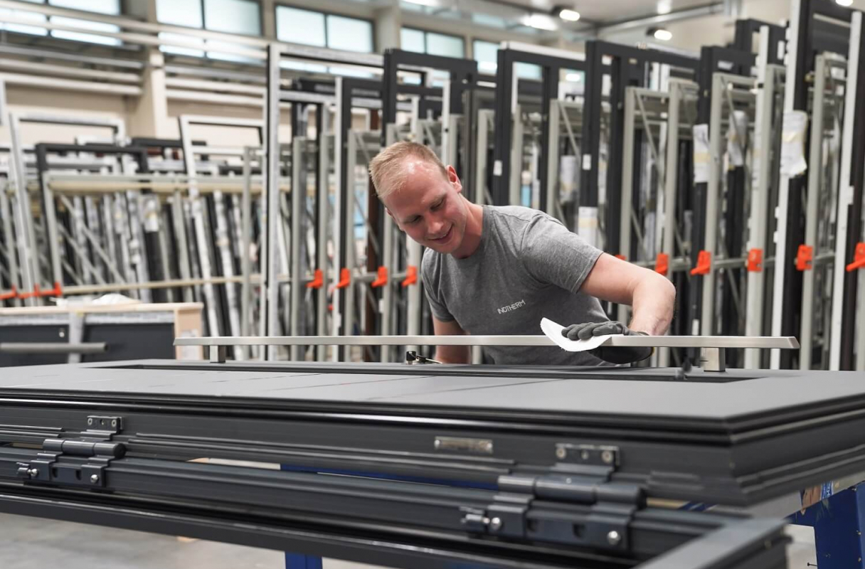 Mitarbeiter reinigt die Eingangstür.