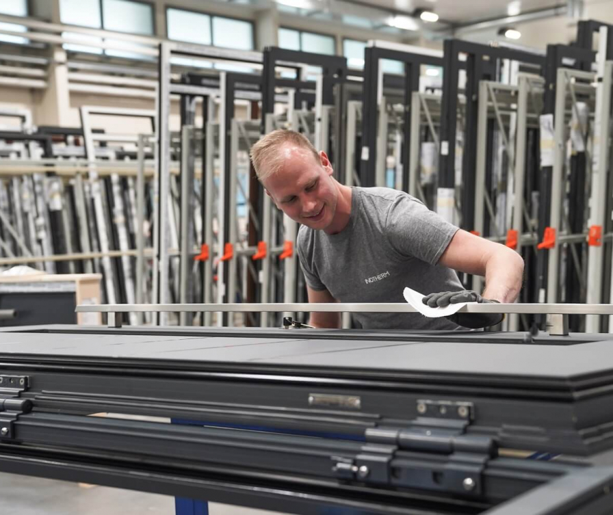 Mitarbeiter reinigt die Eingangstür.