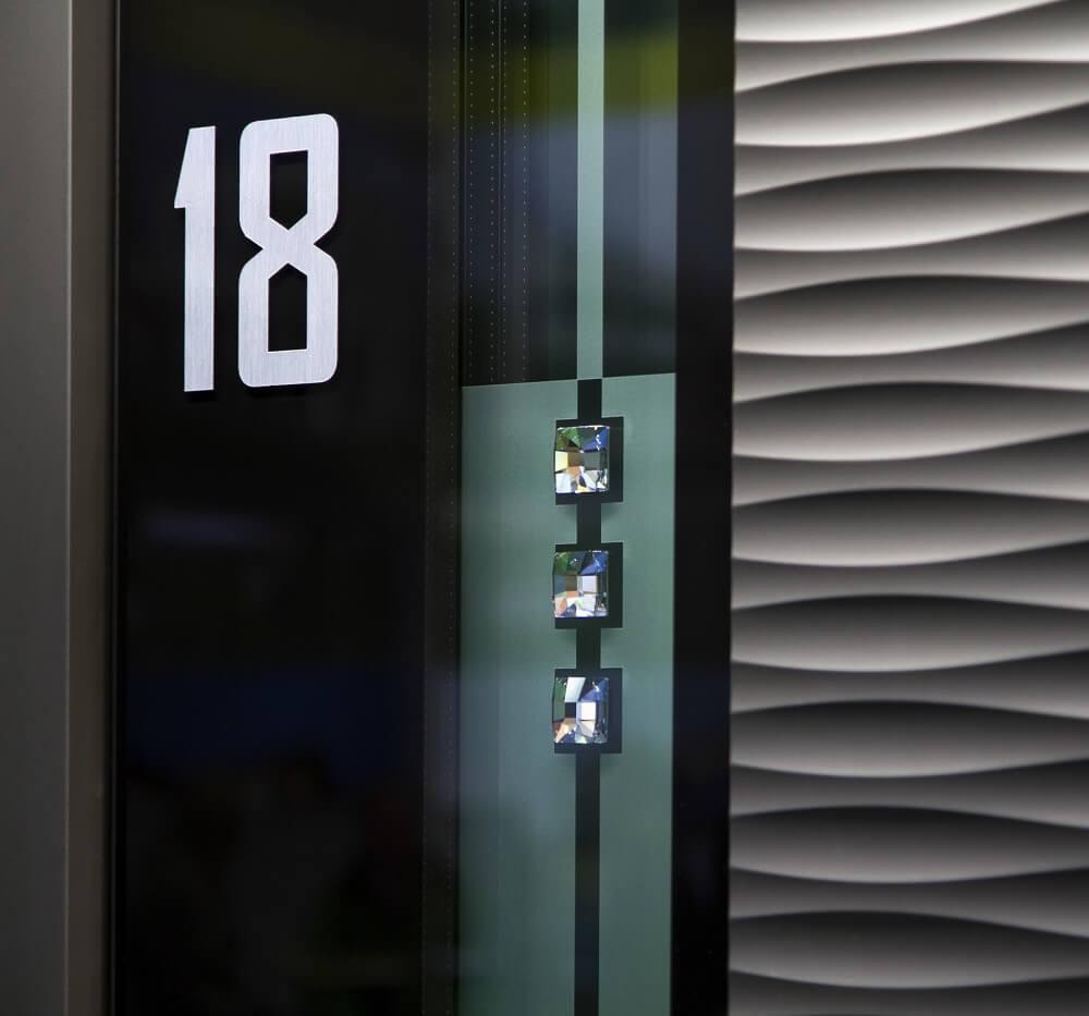 Personalisierte Accessoires an der Haustür: weißes Haus Nummer 18 und Swarovski-Kristalle.