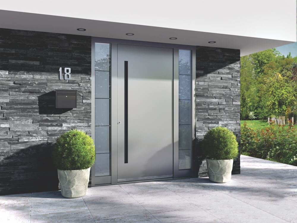 Moderne Aluminium-Haustür in zartem Grau mit Blumendekor am Eingang.