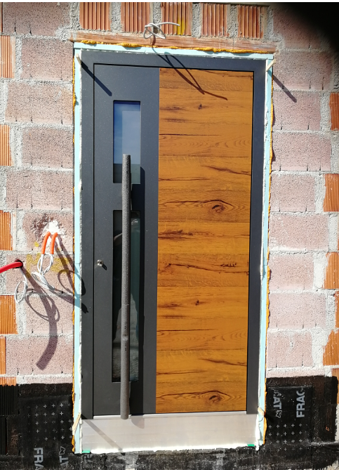 Neue Aluminium-Haustür mit Holzdekor, eingebaut in das neue Haus.v