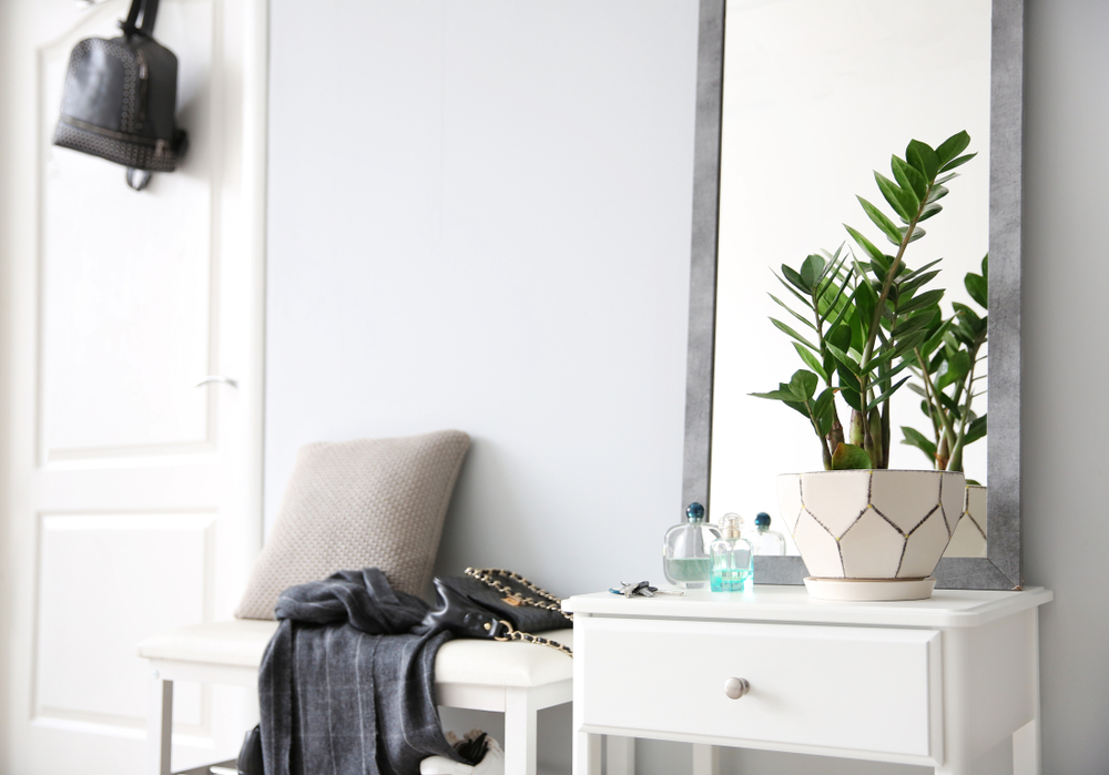 Eine Flur mit weißen Wänden, in welcher sich Kleidung, Schuhe und andere Accessoires befinden.