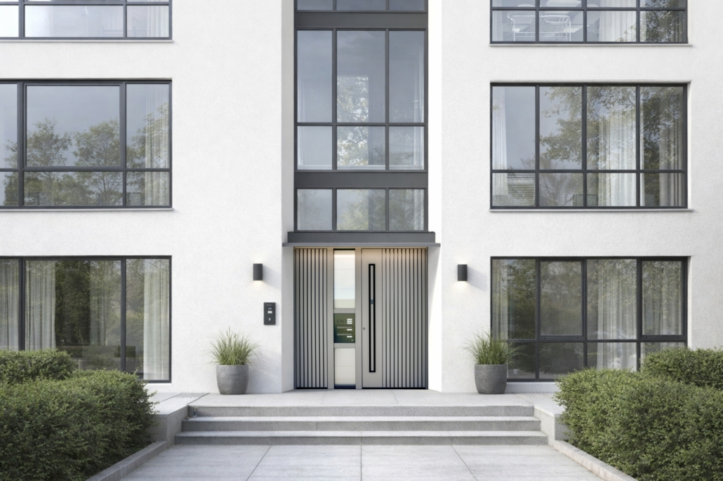 Mehrfamilienhaus mit großen Glasflächen und grauen Haustüren